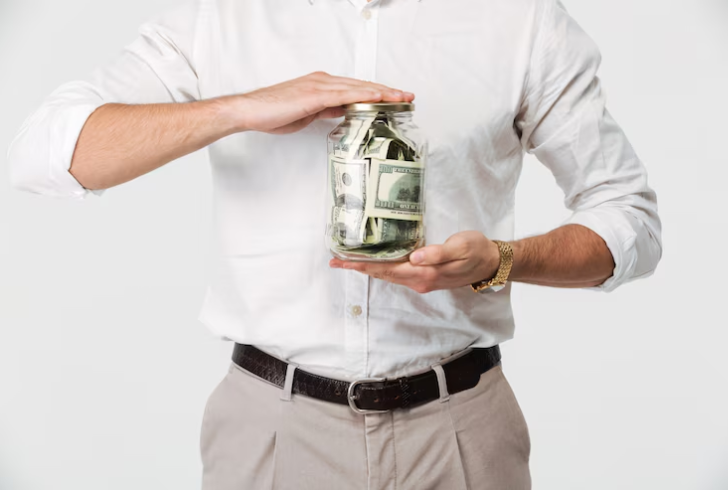 Man holding jar filling with cash