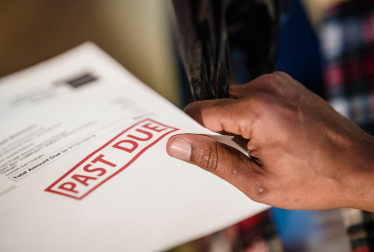 Hand holds an overdue mortgage notice